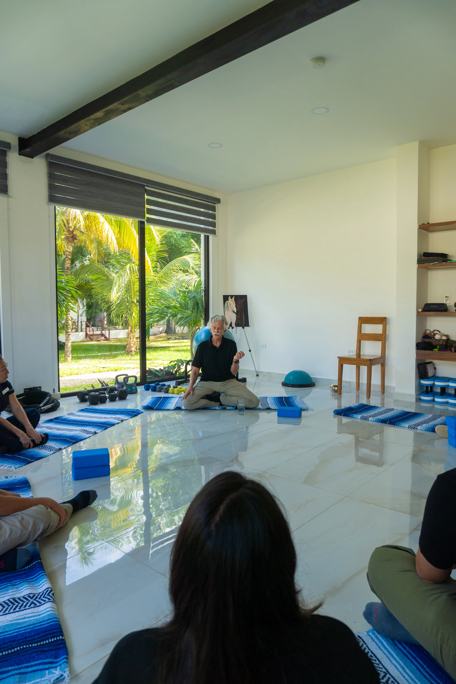 People seated in a bright room with open doors looking onto the clinic garden