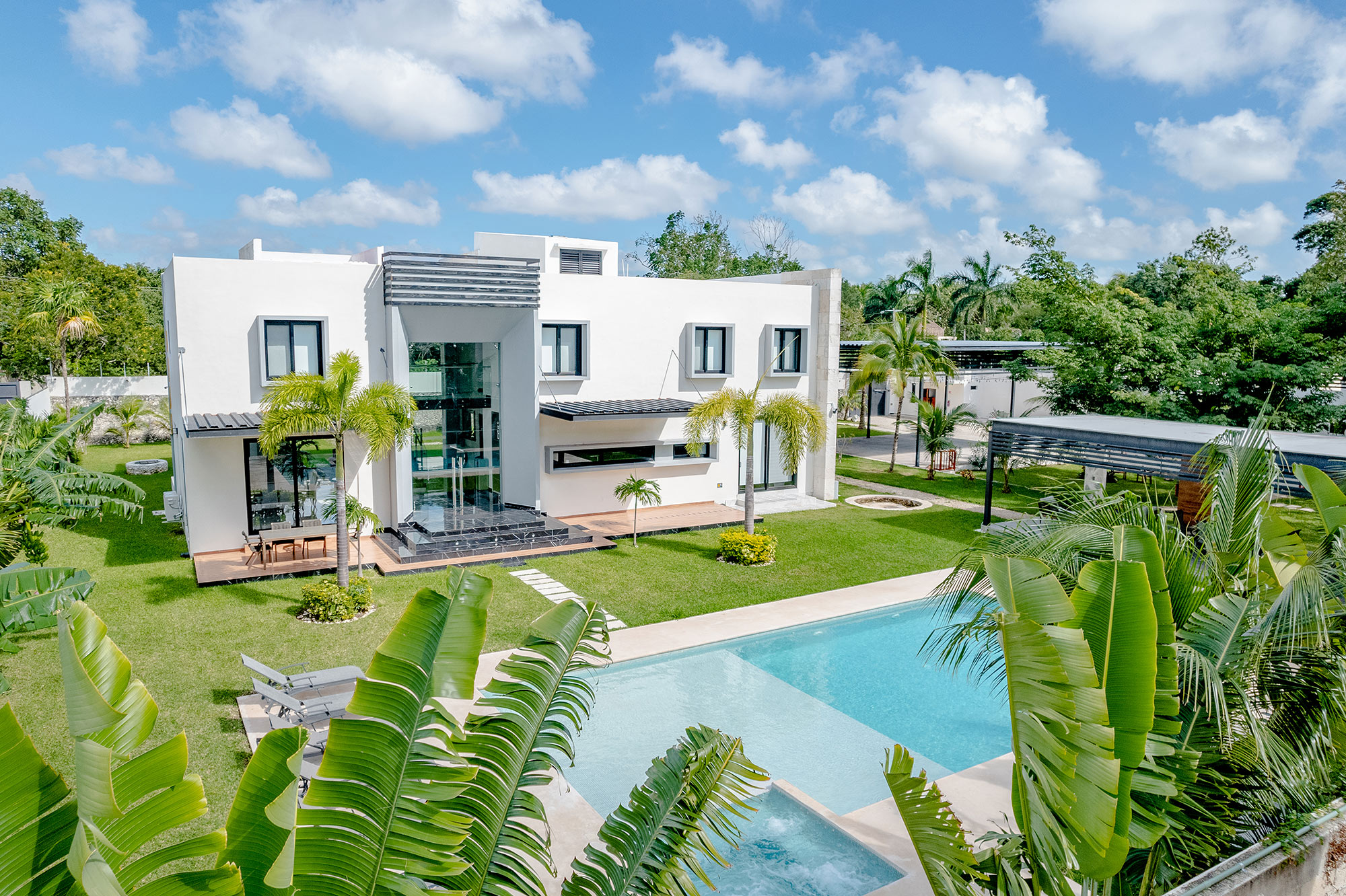 Transcend Clinic in Cancún, with its white building, swimming pool and palm-lined garden
