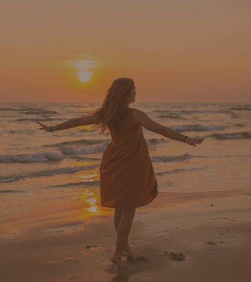 Photo of a woman standing on a serene beach, symbolizing her journey towards overcoming depression and anxiety. The calm waves and open sky reflect her path to mental wellness and inner peace.